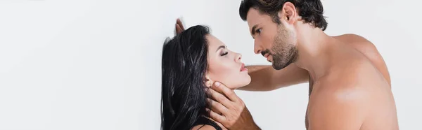 Homme musculaire touchant le cou et regardant femme sexy sur fond blanc, bannière — Photo de stock