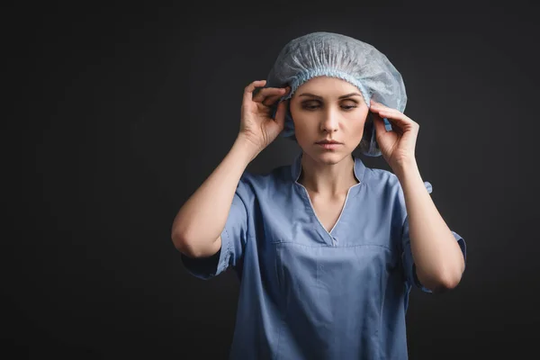 Enfermeira vestindo tampa médica azul isolado no cinza escuro — Fotografia de Stock