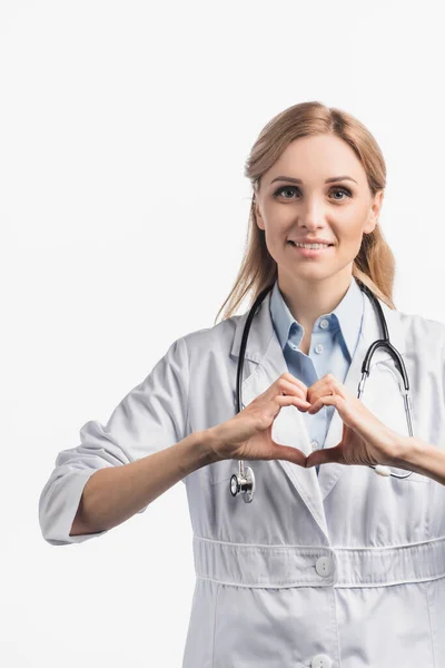Щаслива медсестра в білому пальто, що показує знак слуху з руками ізольовано на білому — стокове фото