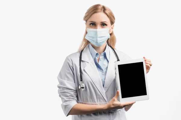 Krankenschwester in medizinischer Maske und weißem Mantel mit digitalem Tablet mit leerem Bildschirm, isoliert auf weißem Hintergrund — Stockfoto