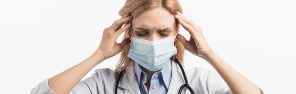 Infirmière en masque médical et manteau blanc souffrant de maux de tête isolé sur blanc, bannière — Photo de stock