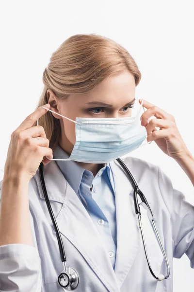 Nurse in white coat wearing medical mask isolated on white — Stock Photo