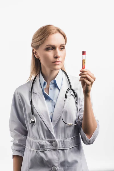 Enfermeira de casaco branco olhando para tubo de ensaio com letras vívidas isoladas em branco — Fotografia de Stock