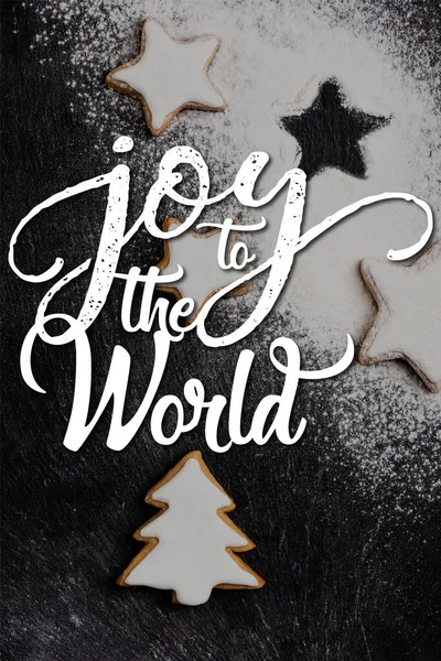 Vue du dessus des biscuits de pain d'épice de Noël couverts de poudre de sucre près de joie au lettrage du monde — Photo de stock