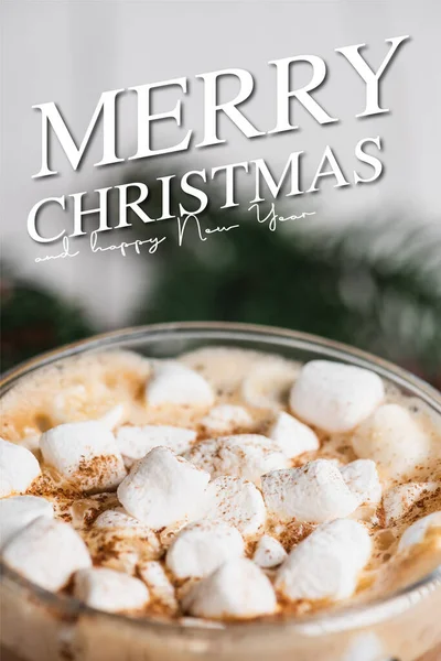 Vista de cerca de la taza de vidrio de cacao con malvaviscos y canela cerca de feliz Navidad y feliz año nuevo letras - foto de stock