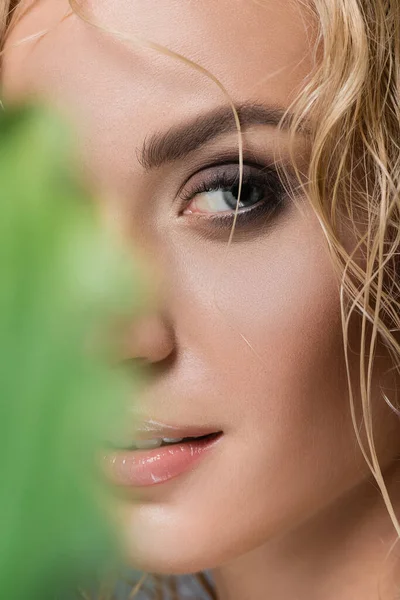 Closeup of blonde woman with wet hair and green leaf — Stock Photo