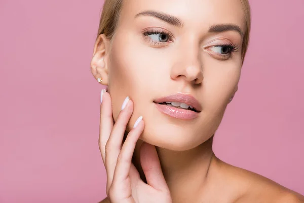 Beautiful blonde woman with perfect skin touching face isolated on pink — Stock Photo