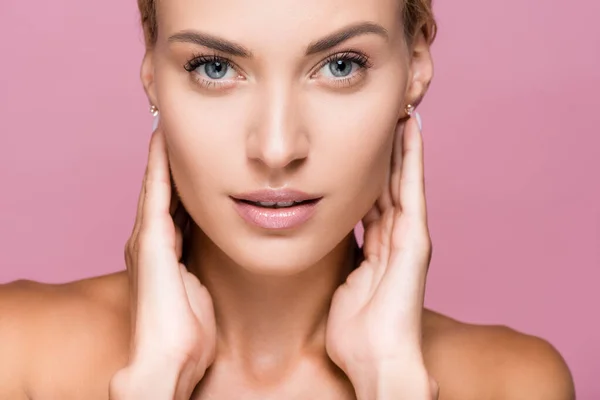 Beautiful blonde woman with perfect skin touching face isolated on pink — Stock Photo