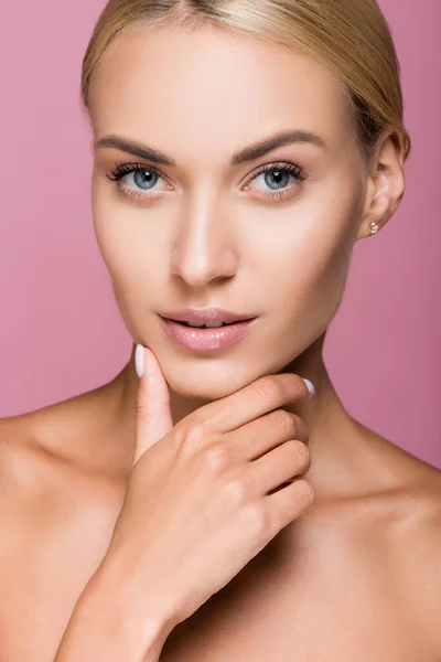 Beautiful blonde woman with perfect skin touching face isolated on pink — Stock Photo