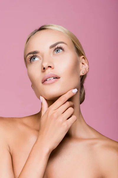 Belle femme blonde avec peau parfaite toucher visage isolé sur rose — Photo de stock