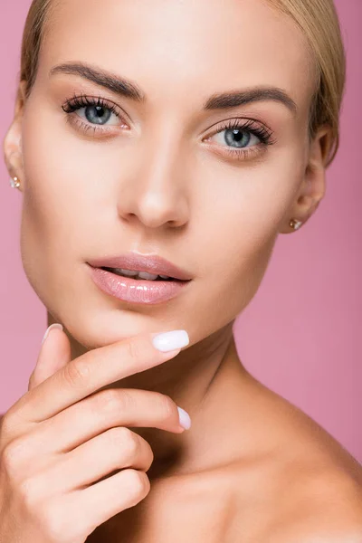 Belle femme blonde avec peau parfaite toucher visage isolé sur rose — Photo de stock