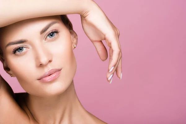 Beautiful blonde woman posing with hand isolated on pink — Stock Photo