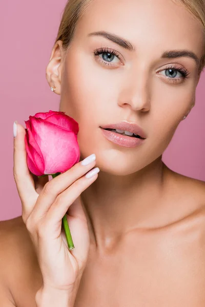 Hermosa mujer rubia con la piel perfecta y flor de rosa aislado en rosa — Stock Photo