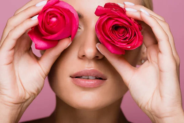 Beautiful blonde woman with rose flowers on eyes isolated on pink — Stock Photo