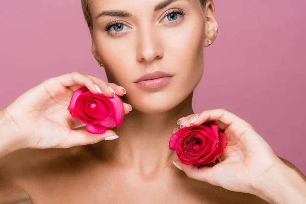 Hermosa mujer rubia con flores de rosas aisladas en rosa - foto de stock