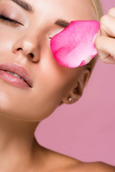 Belle femme blonde à la peau parfaite et pétale de rose isolé sur rose — Photo de stock