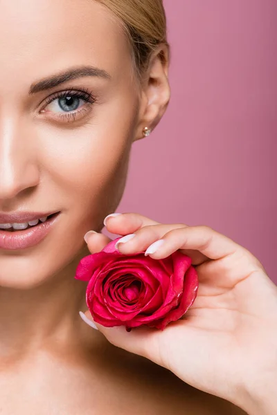 Vue recadrée de belle femme blonde à la peau parfaite et fleur rose isolée sur rose — Photo de stock
