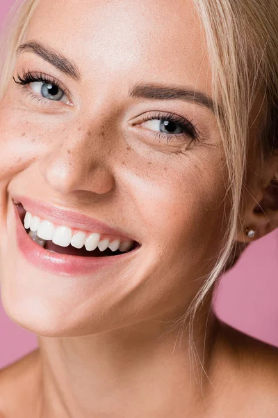 Sorridente bella donna bionda con lentiggini isolato su rosa — Foto stock