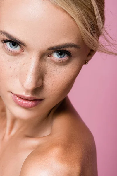 Beautiful blonde woman with freckles and bare shoulders isolated on pink — Stock Photo