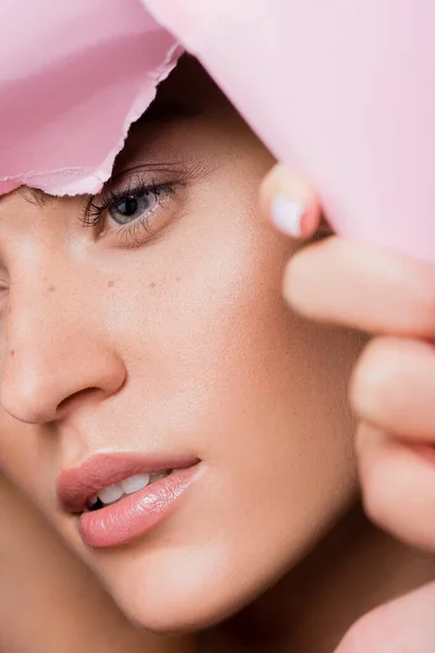 Nahaufnahme einer schönen Frau mit Sommersprossen im rosa Papierloch — Stockfoto