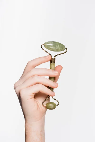 Vista cortada da mão feminina com vitiligo e jade rolo isolado em branco — Fotografia de Stock