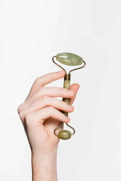 Cropped view of female hand with vitiligo and jade roller isolated on white — Stock Photo