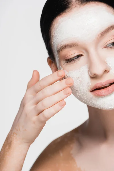 Jeune belle femme avec vitiligo et masque d'argile sur le visage isolé sur blanc — Photo de stock