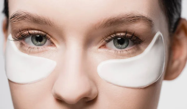 Cropped view of woman with eye patches on face — Stock Photo