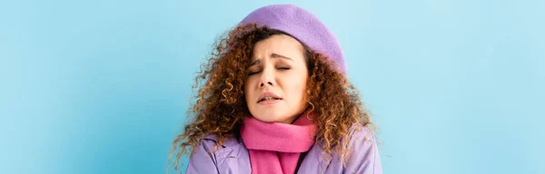 Young curly woman in beret freezing on blue background, banner — Stock Photo