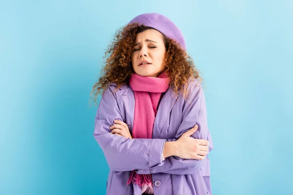 Jeune femme bouclée avec les yeux fermés gelant et s'embrassant sur fond bleu — Photo de stock