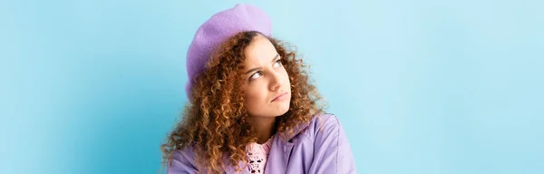 Displeased woman in beret looking away on blue, banner — Stock Photo