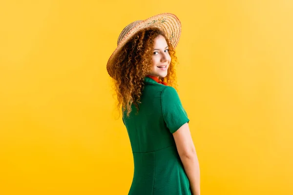 Felice giovane donna in cappello di paglia e vestito verde isolato su giallo — Foto stock