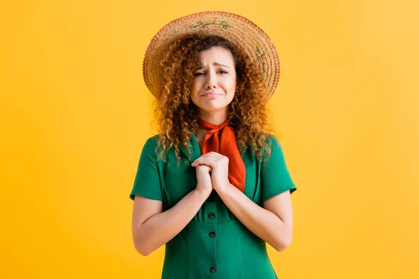 Mujer triste y rizada en sombrero de paja y vestido verde en amarillo - foto de stock