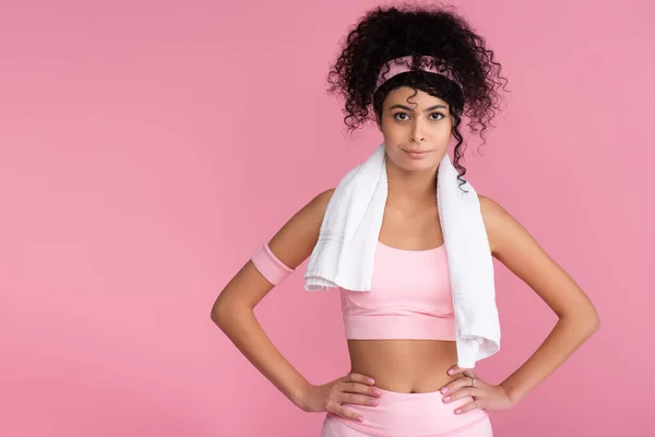 Jeune sportive bouclée debout avec les mains sur les hanches isolées sur rose — Photo de stock