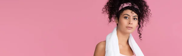 Curly young sportswoman looking at camera isolated on pink, banner — Stock Photo