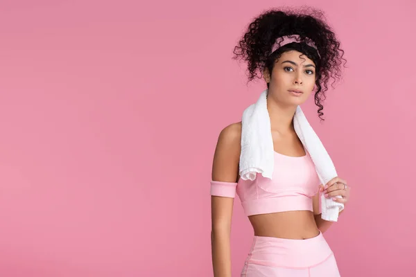 Curly young sportswoman with towel on shoulders standing isolated on pink — Stock Photo