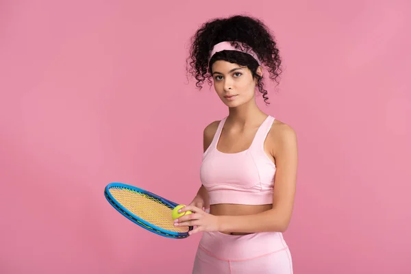 Young sportive woman holding tennis racket with ball isolated on pink — Stock Photo