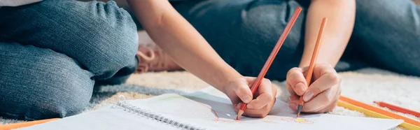 Ausgeschnittene Ansicht von Mutter und Tochter mit Buntstiften Zeichnung in Kopierbuch auf dem Boden, Banner — Stockfoto