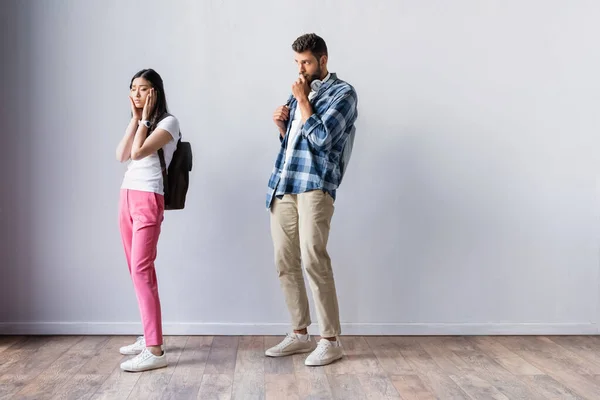 Besorgter asiatischer Student steht vor Prüfung in Halle neben Mann — Stockfoto