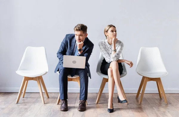 Uomini d'affari con laptop in attesa di un colloquio di lavoro in sala — Foto stock