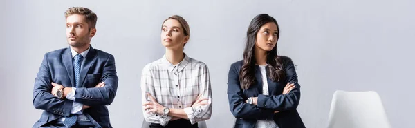 Multiethnic business people sitting with crossed arms in hall, banner — Stock Photo