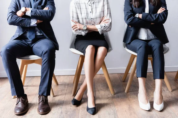 Обрізаний погляд на бізнесменів, які чекають на стільці в офісі — стокове фото