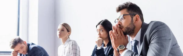 Uomo d'affari in attesa di un colloquio di lavoro vicino a uomini d'affari multietnici in sala in ufficio, banner — Foto stock