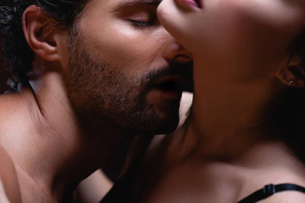 Nahaufnahme eines jungen Mannes, der einer verführerischen Frau den Hals küsst — Stockfoto