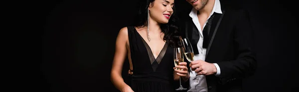 Happy couple holding glasses of champagne isolated on black, banner — Stock Photo