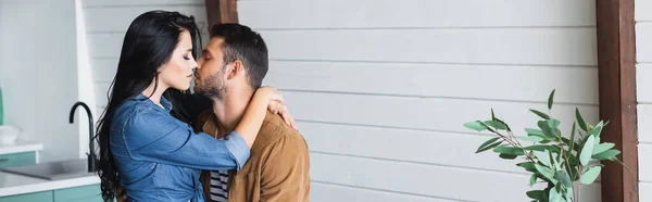 Jovem morena abraçando e beijando namorado na cozinha, banner — Fotografia de Stock