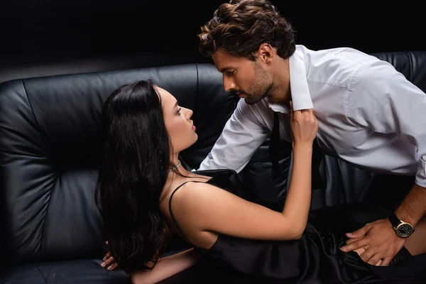 Сексуальная брюнетка женщина раздетая мужчина в белой рубашке на черном — стоковое фото