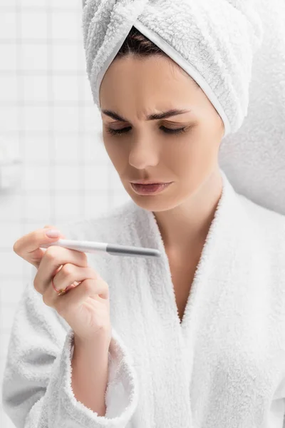 Concentrated woman with towel on head looking at pregnancy test — Stock Photo