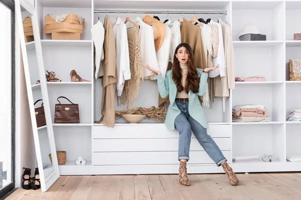 Besorgte Frau zeigt mit Händen im Kleiderschrank — Stockfoto