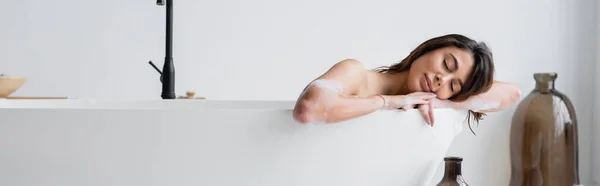 Brunette femme avec les yeux fermés couché dans la baignoire, bannière — Photo de stock